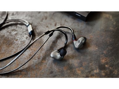 Casque intra-auriculaire Sennheiser IE 600 noir, écouteurs métalliques, câble tressé, sur surface texturée marron foncé