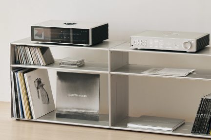 Étagère métallique rectangulaire avec 6 compartiments contenant vinyles, CD, livres, lecteur réseau et amplificateur audio