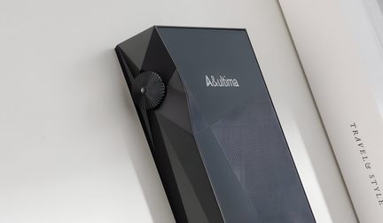 Aparat dreptunghiular negru cu suprafață texturată, buton rotativ circular pe lateral și logo alb deasupra.