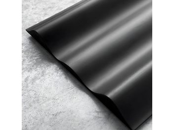 Feuille ondulée noire mate, vue rapprochée en perspective, surface texturée avec de fines stries parallèles régulières