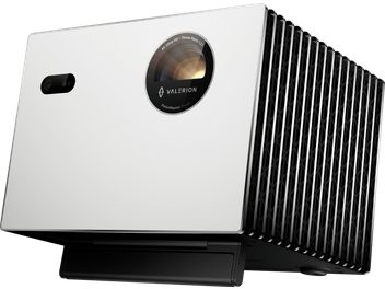 Vidéoprojecteur Valerion StreamMaster Plus 2, boîtier rectangulaire blanc mat en métal avec grille latérale noire ajourée et lentille circulaire cerclée de noir sur la façade, vue en perspective avant droite légèrement en contre-plongée