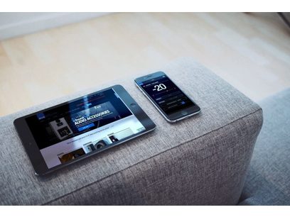 SVS SB-2000 Pro black ash subwoofer, black ash finish, and smartphone displaying settings, placed on a gray fabric