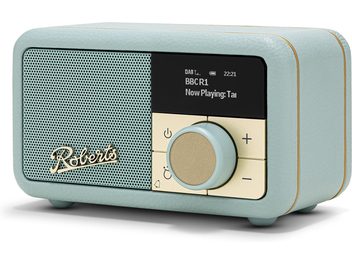 Radio Roberts Revival Petite 2 v nebesno modri barvi s teksturiranim umetnim usnjem, pogled z desne sprednje strani, z veliko preperforirano rešto, črnim digitalnim zaslonom in zlato obrobljenim vijačnim regulatorjem