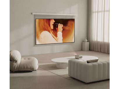 Écran de projection montrant une femme chantant dans un microphone, dans un intérieur moderne avec canapés et poufs blancs
